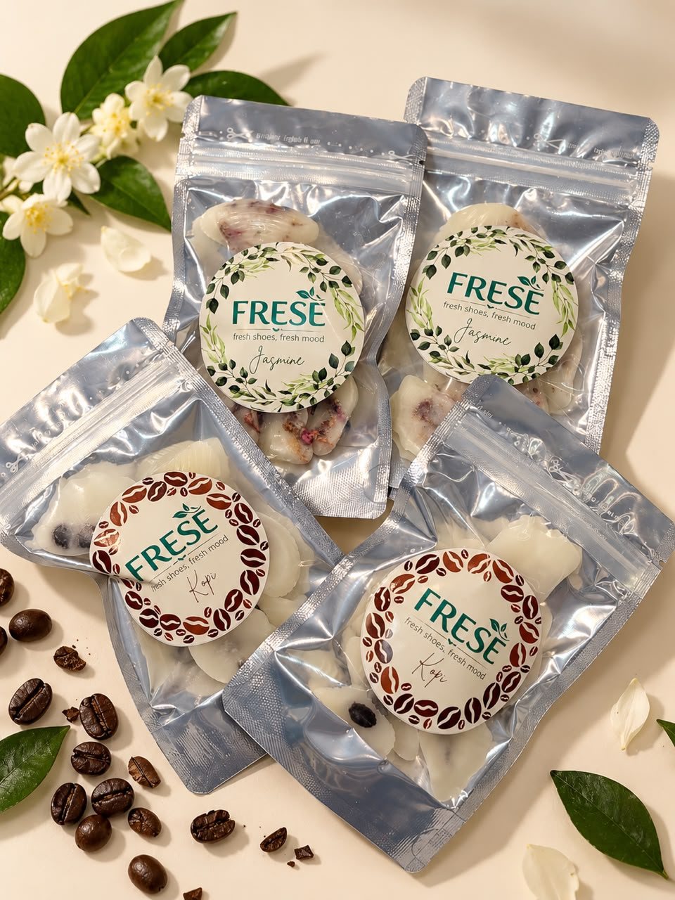 Empat sachet FRESÈ aroma Jasmine dan Kopi di antara bunga melati dan biji kopi